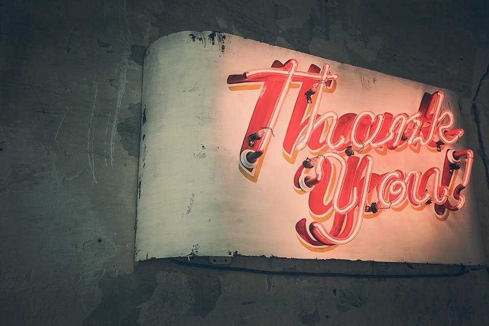 metal sign with neon lettering that reads "thank you"